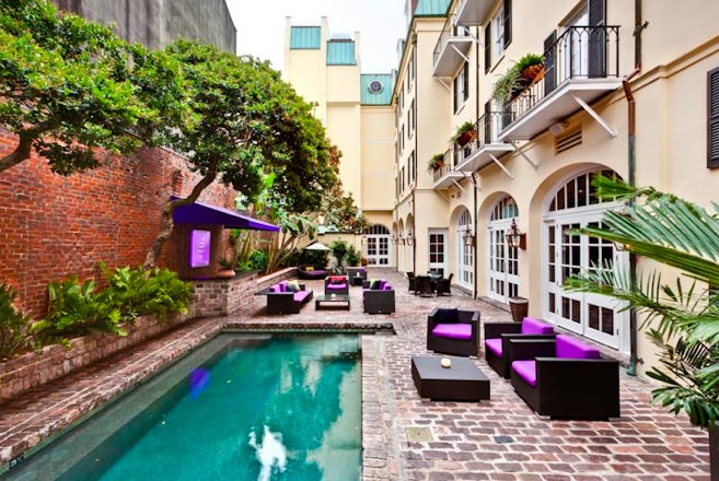a pool in a courtyard with purple furniture