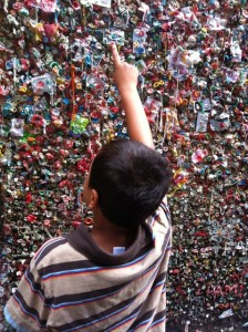 a boy pointing at a wall of gum