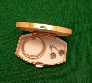 a gold ring and earrings in a small box