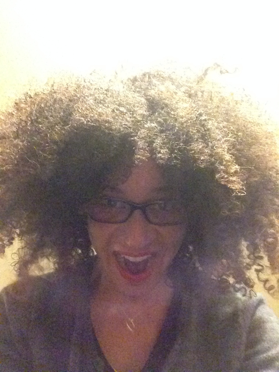 a woman with curly hair and glasses
