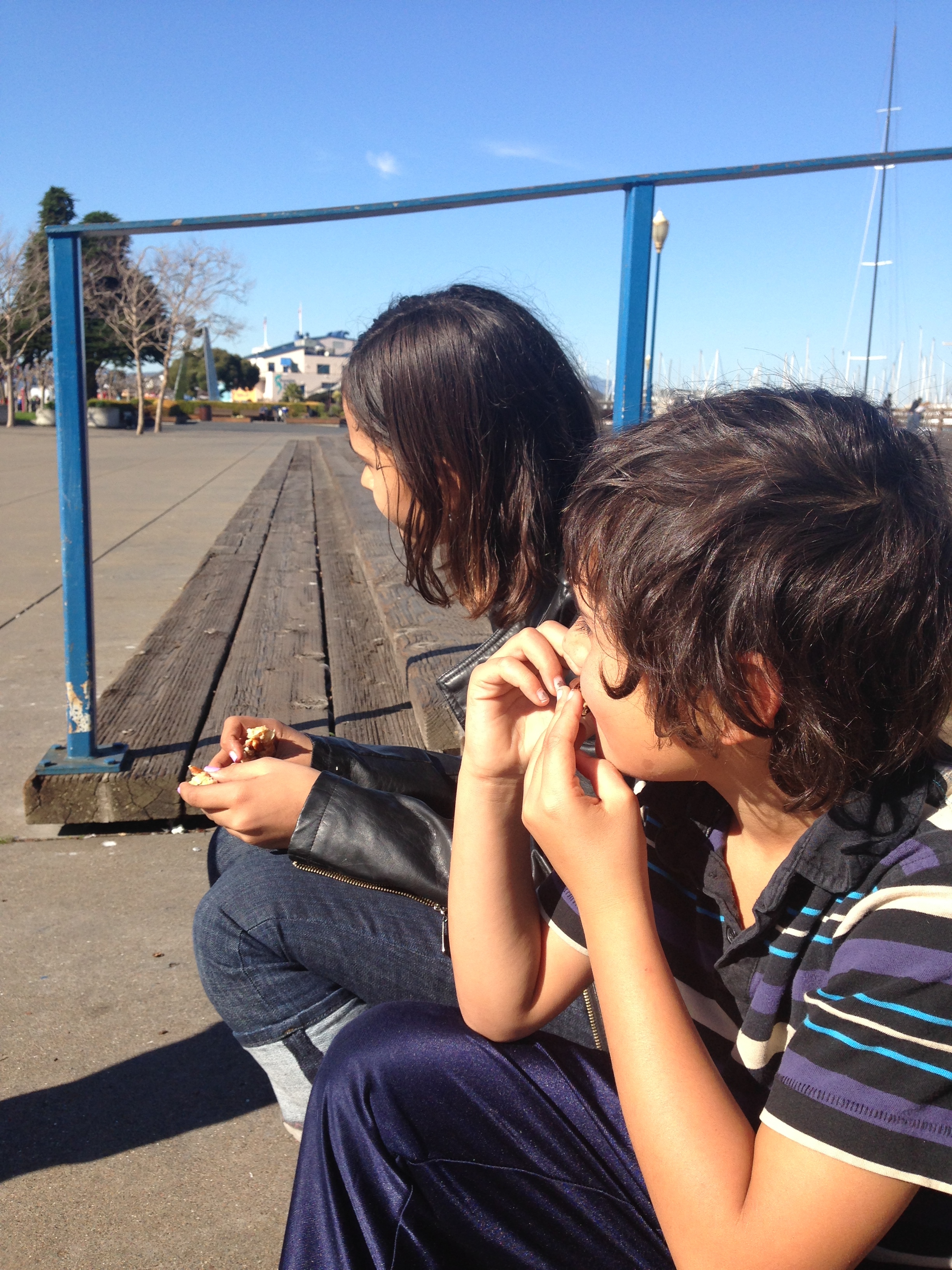 a boy and girl sitting on a bench