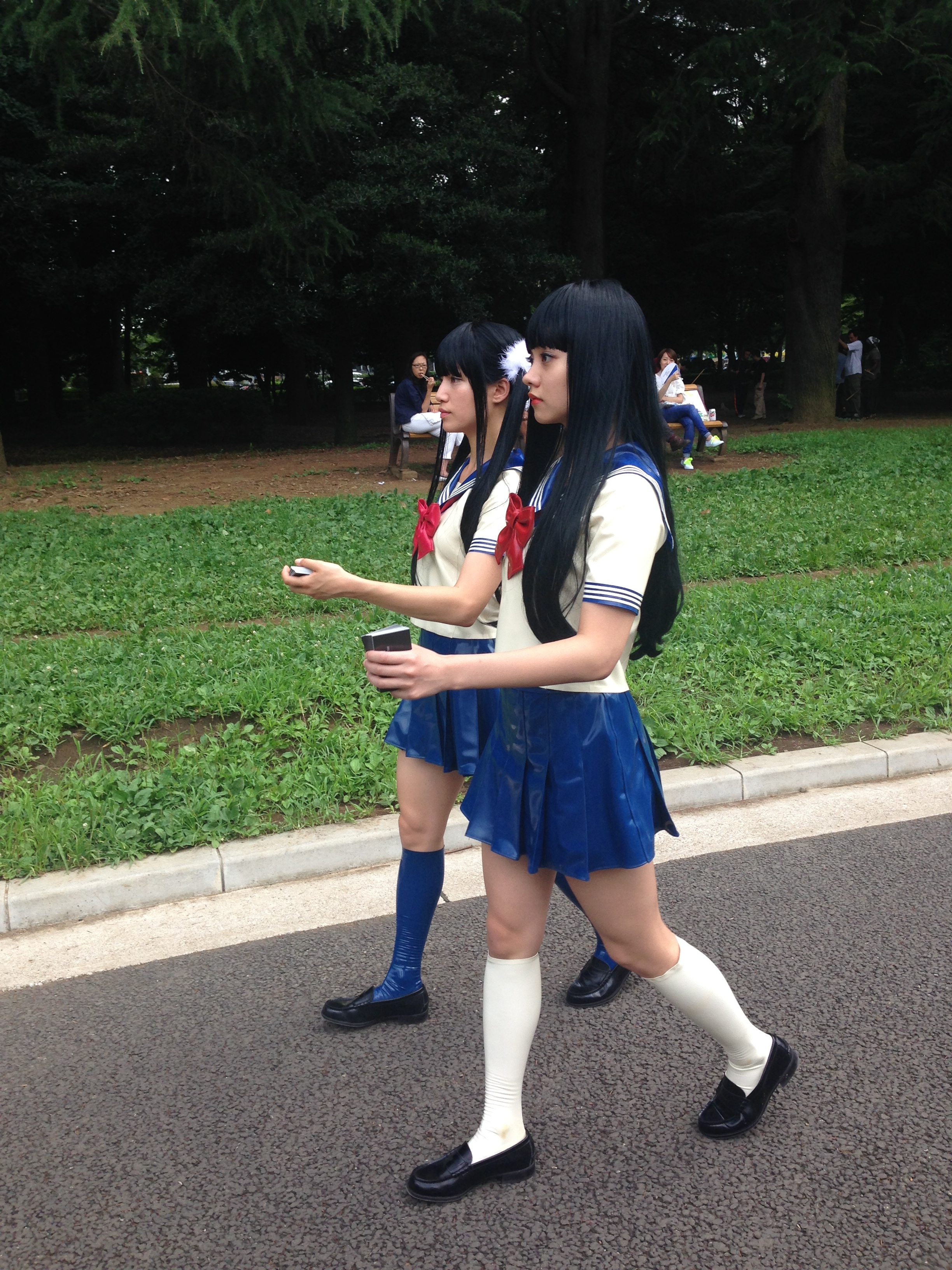two women in school uniforms walking on a street