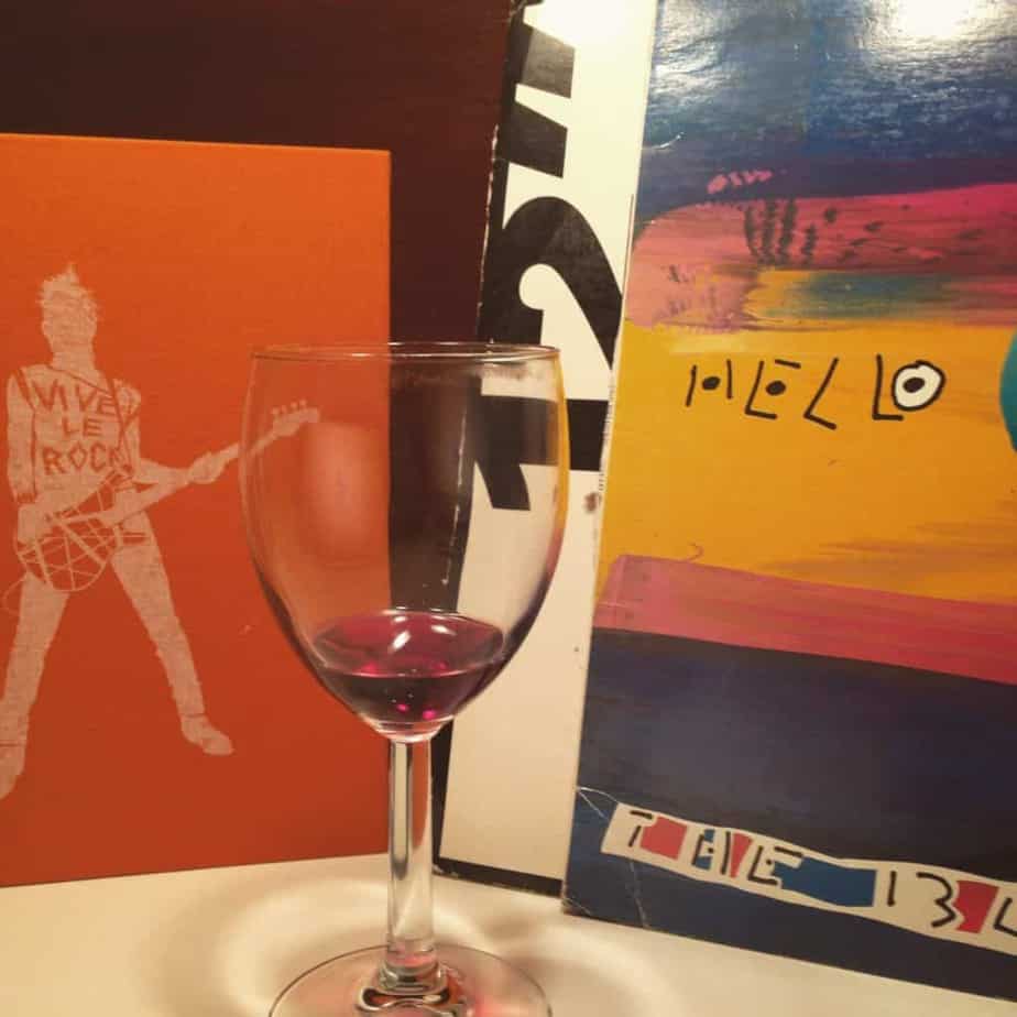 a glass of wine next to a painting