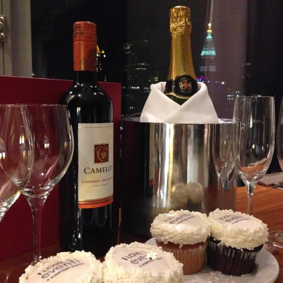 a wine bottle and cupcakes on a table